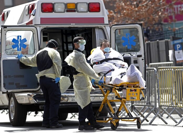 zdravotníci v ochranných odevoch prevoz pacient nemocnica Elmhurst Hospital Center, New York