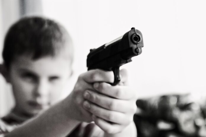 child, holding a gun, point